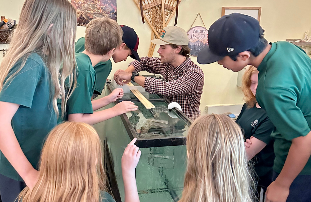 teacher and students looking into a fish tank