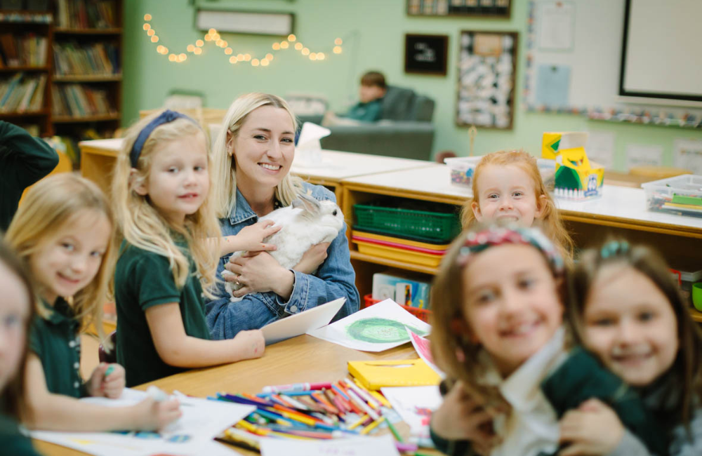 Teacher holding bunny with 1st graders